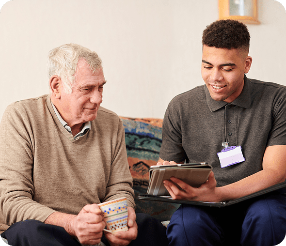Elderly man and caregiver with tablet